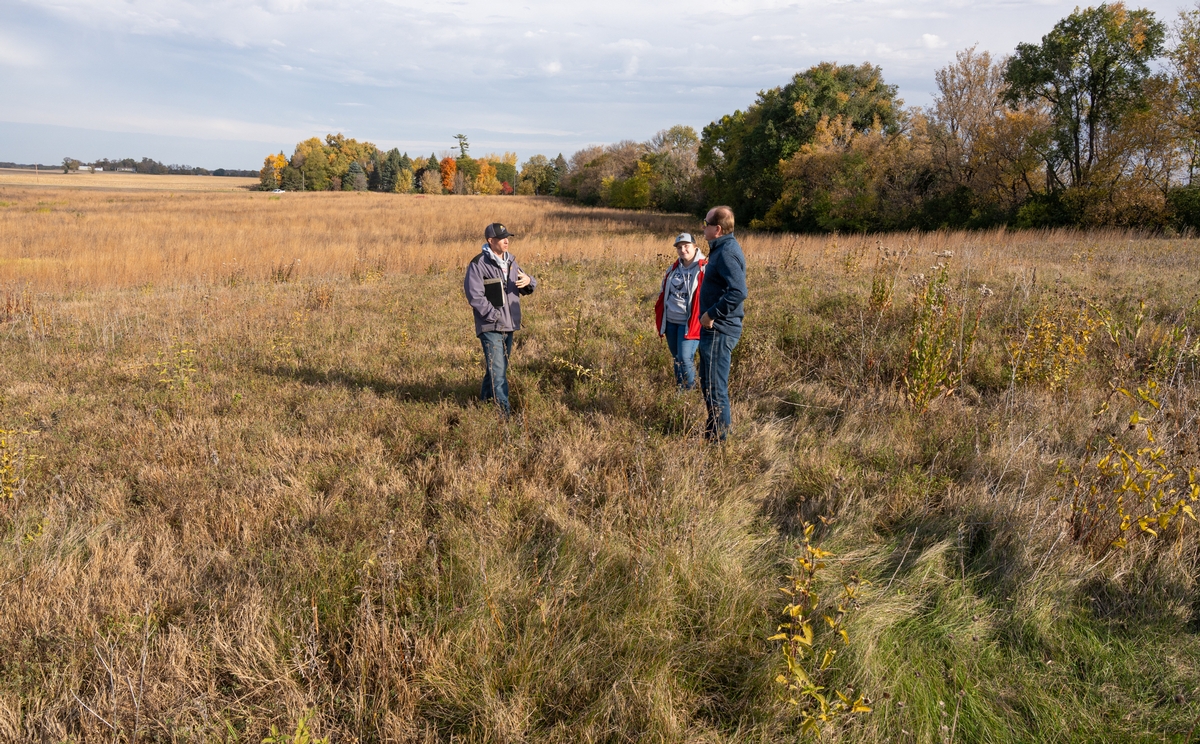 Pheasants Forever Minnesota Private Lands Manager Josh Pommier and Farm Bill Biologist Brittney Hubbell talk with landowner Kirk Quade about results of pollinator-focused habitat improvements on an area of permanently protected land near Hutchinson. Easement Enhancement Grant news